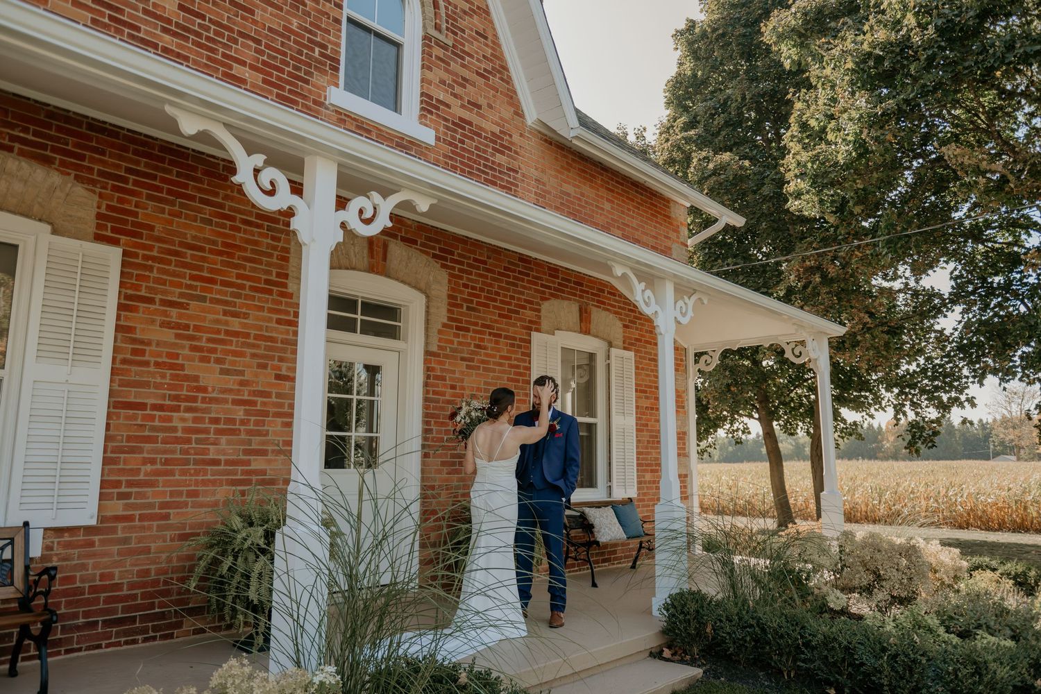 Elegant red brick home exterior with white trim and columns showcases classic American architecture details.