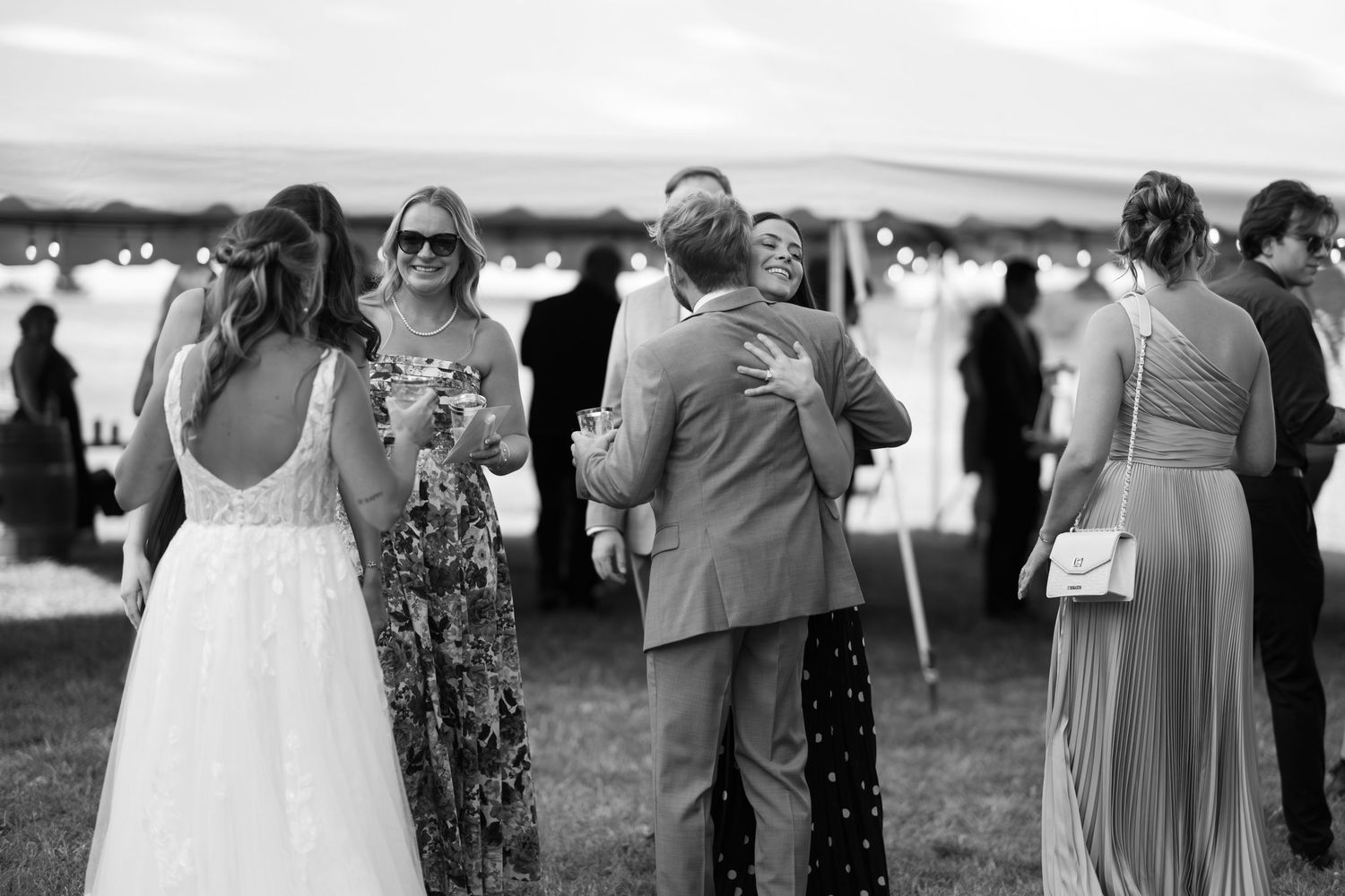 Wedding guests dancing and celebrating together on an outdoor dance floor during a reception.
