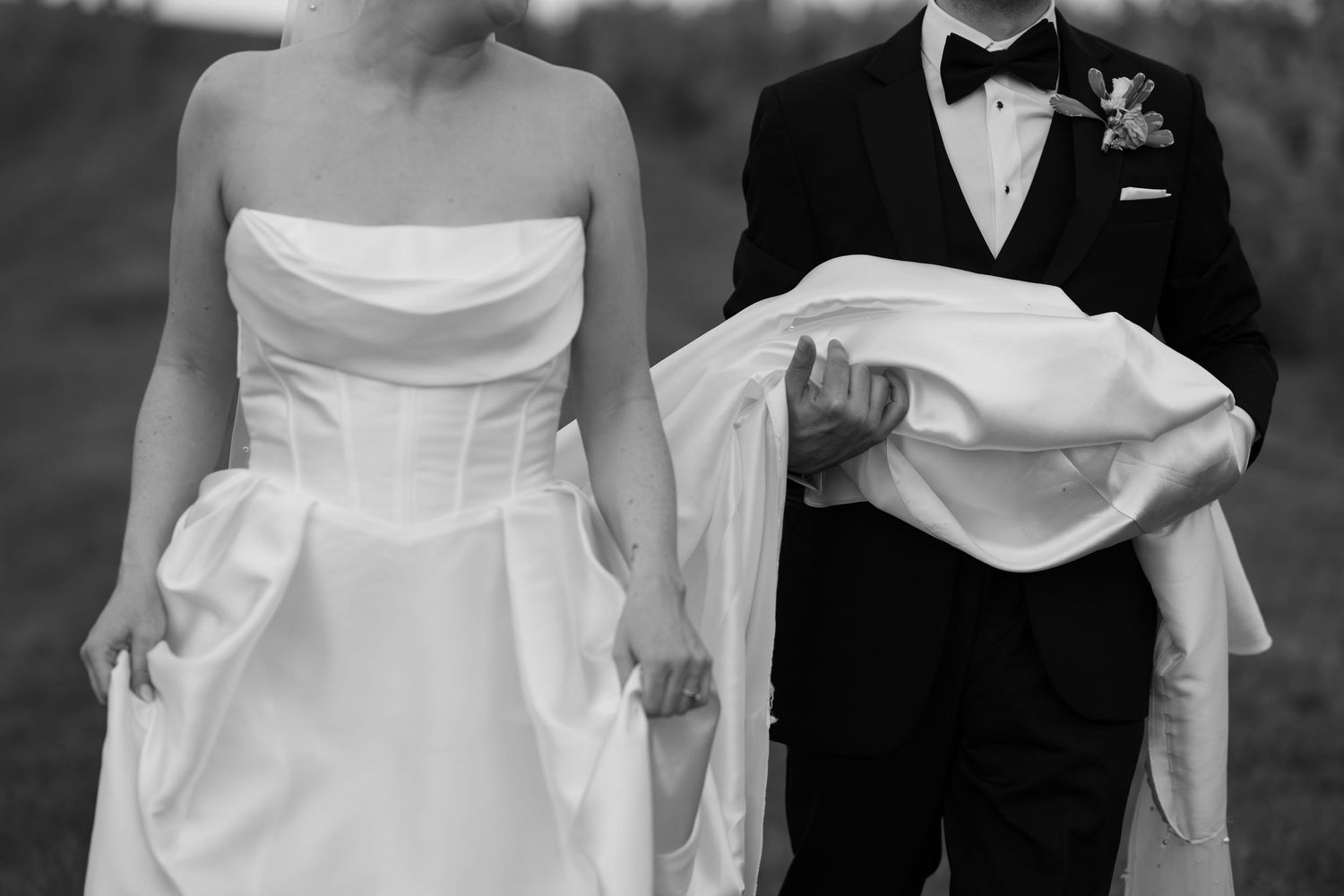 Elegant wedding attire details showing black tuxedo and white bridal gown.