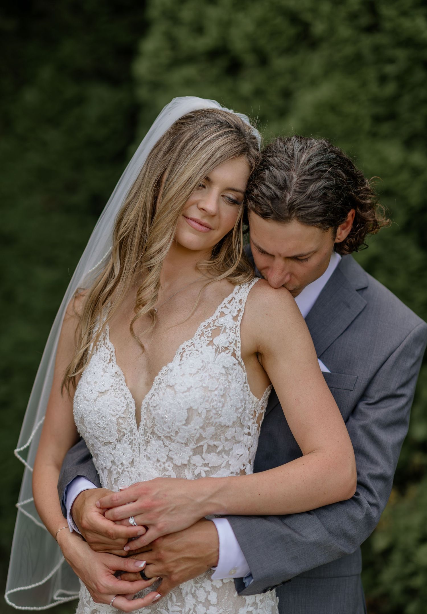Intimate embrace between newlyweds during outdoor wedding photoshoot.