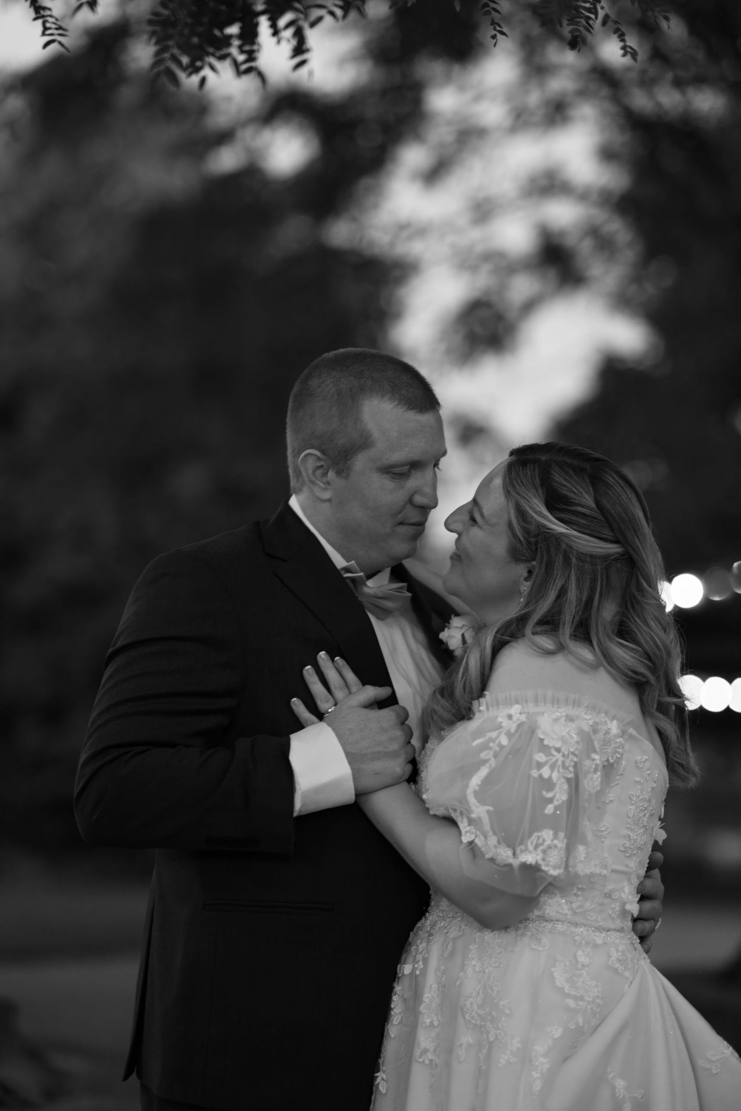 A romantic black and white photo series showing tender moments between a couple in wedding attire.