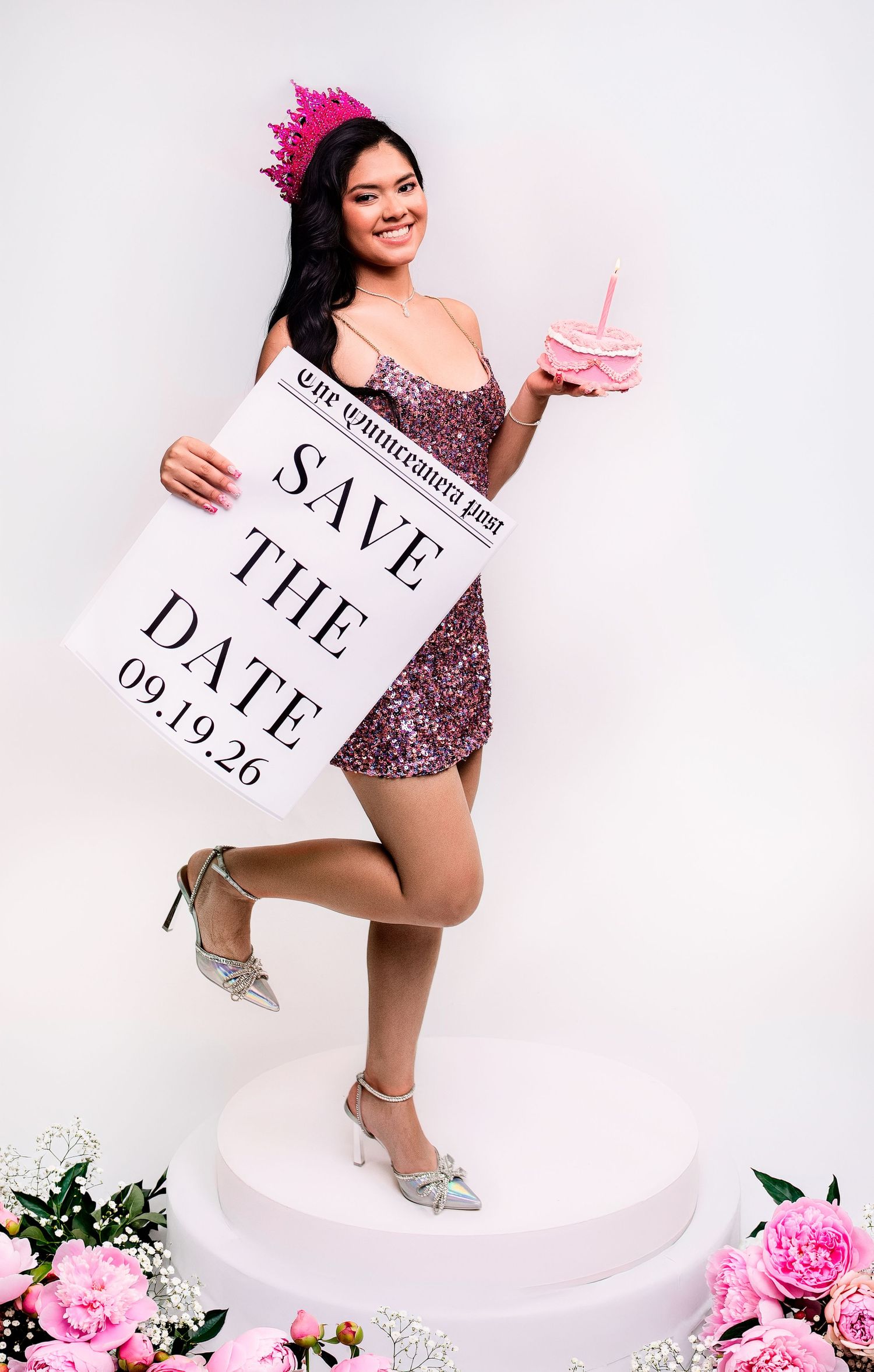 Young woman in pink sequin dress holds Save the Date sign for Quinceañera on 09.19.26, wearing crown and heels.