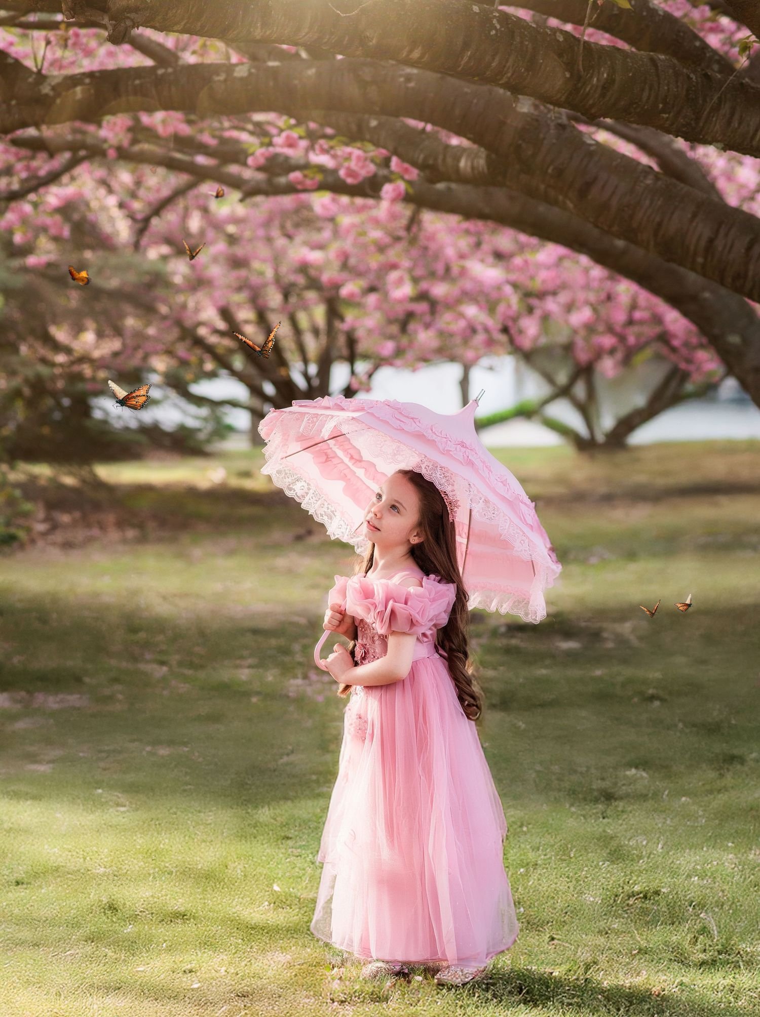 Young girl in pink dress holding lace umbrella under blooming cherry blossom trees with butterflies.