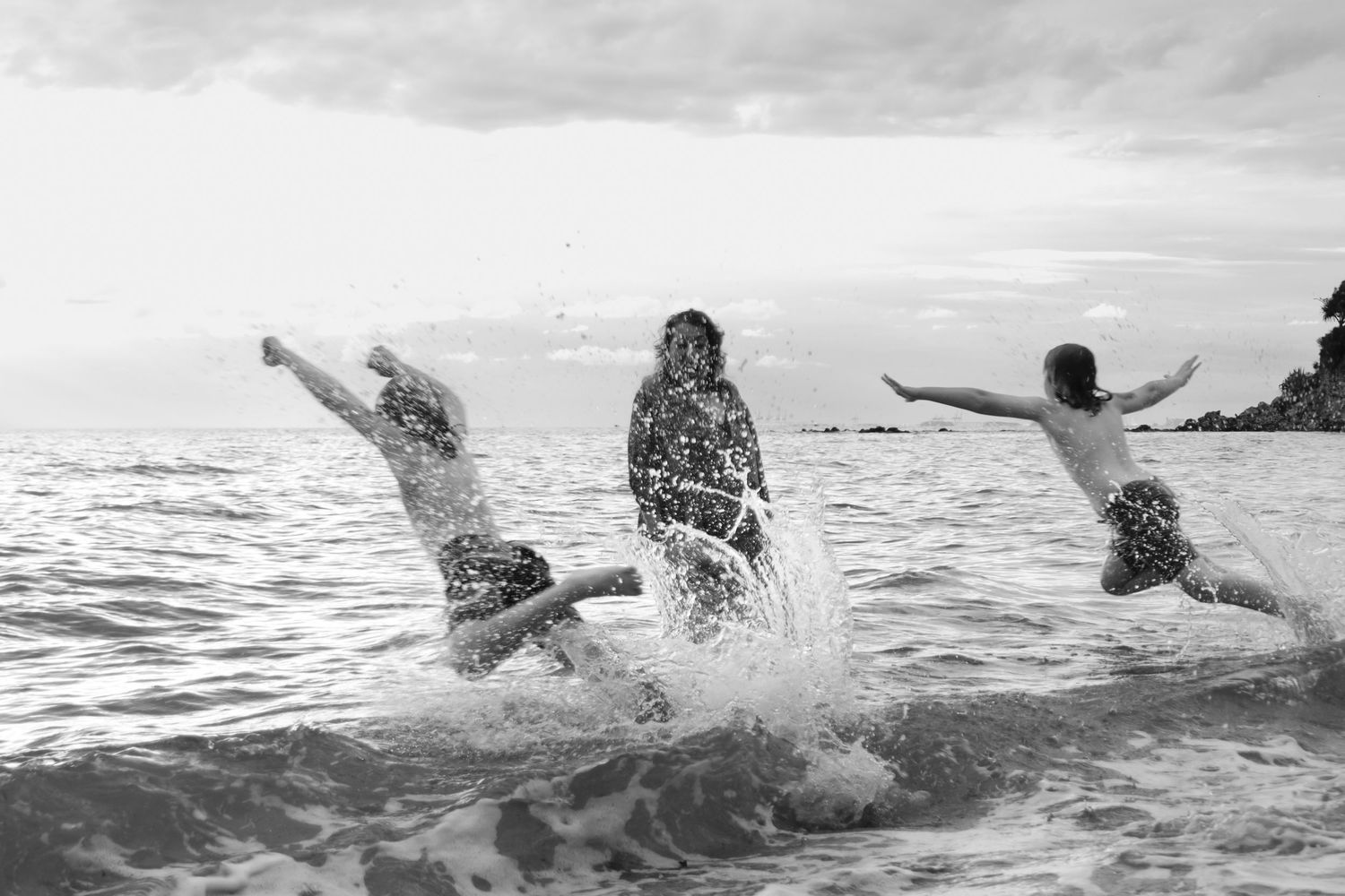 black and white image of children running into the water