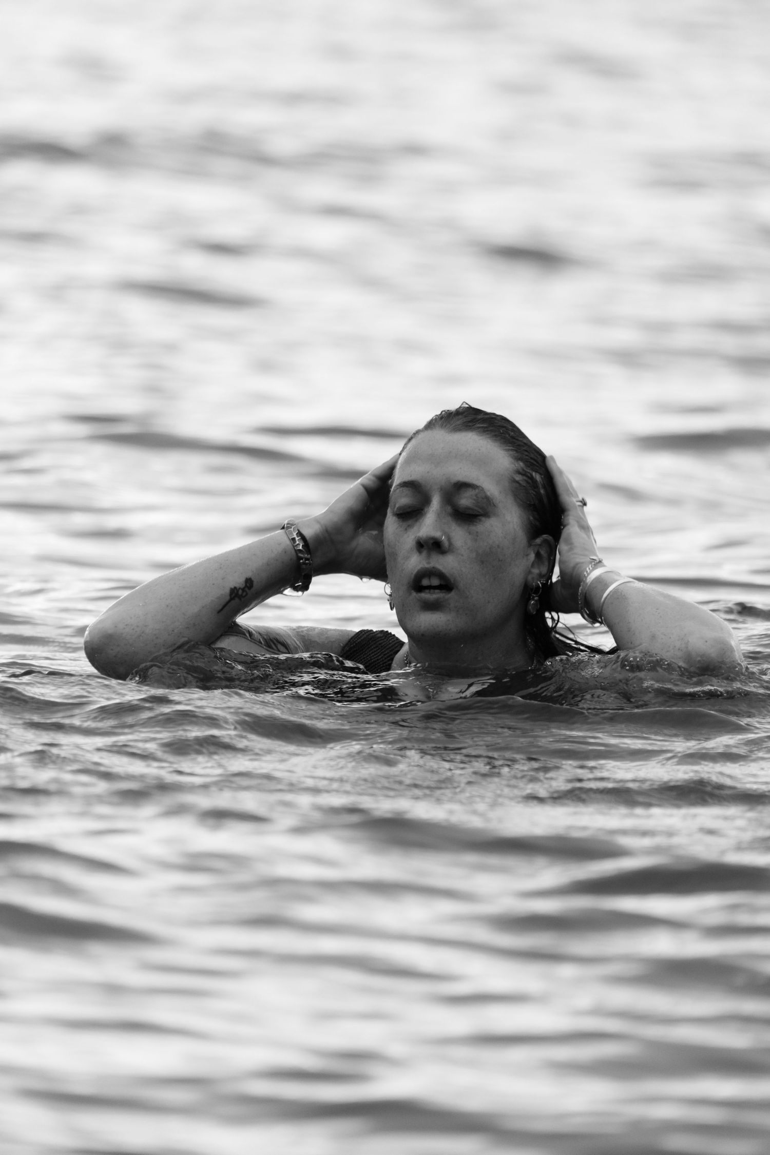 black and white photo of a woman in the water at the beach