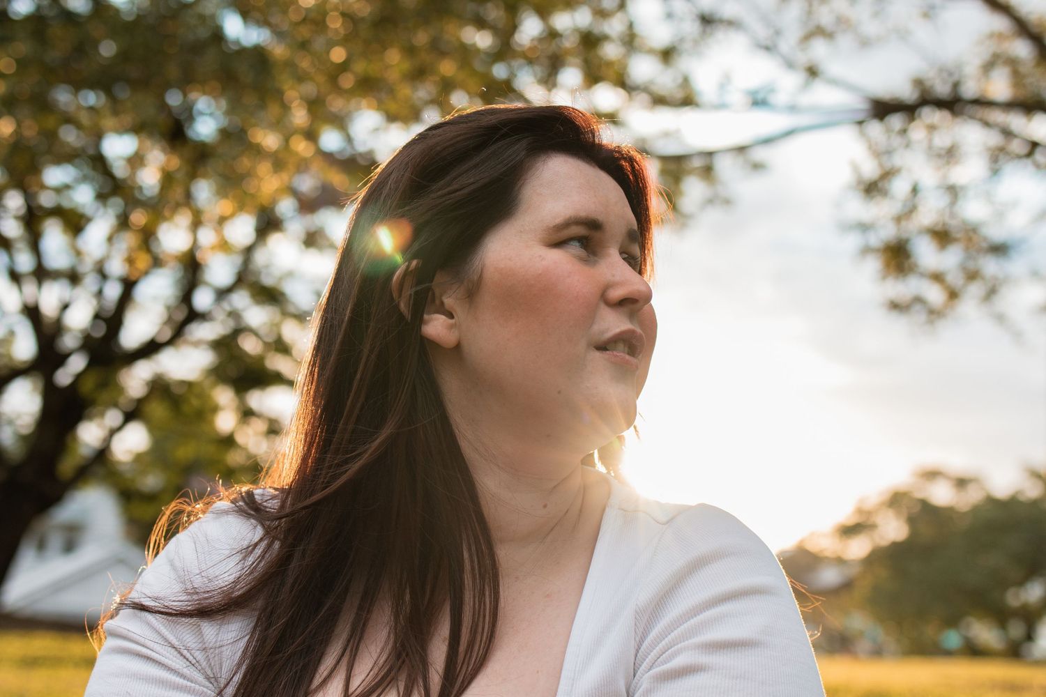 woman looking off as the sunsets behind her