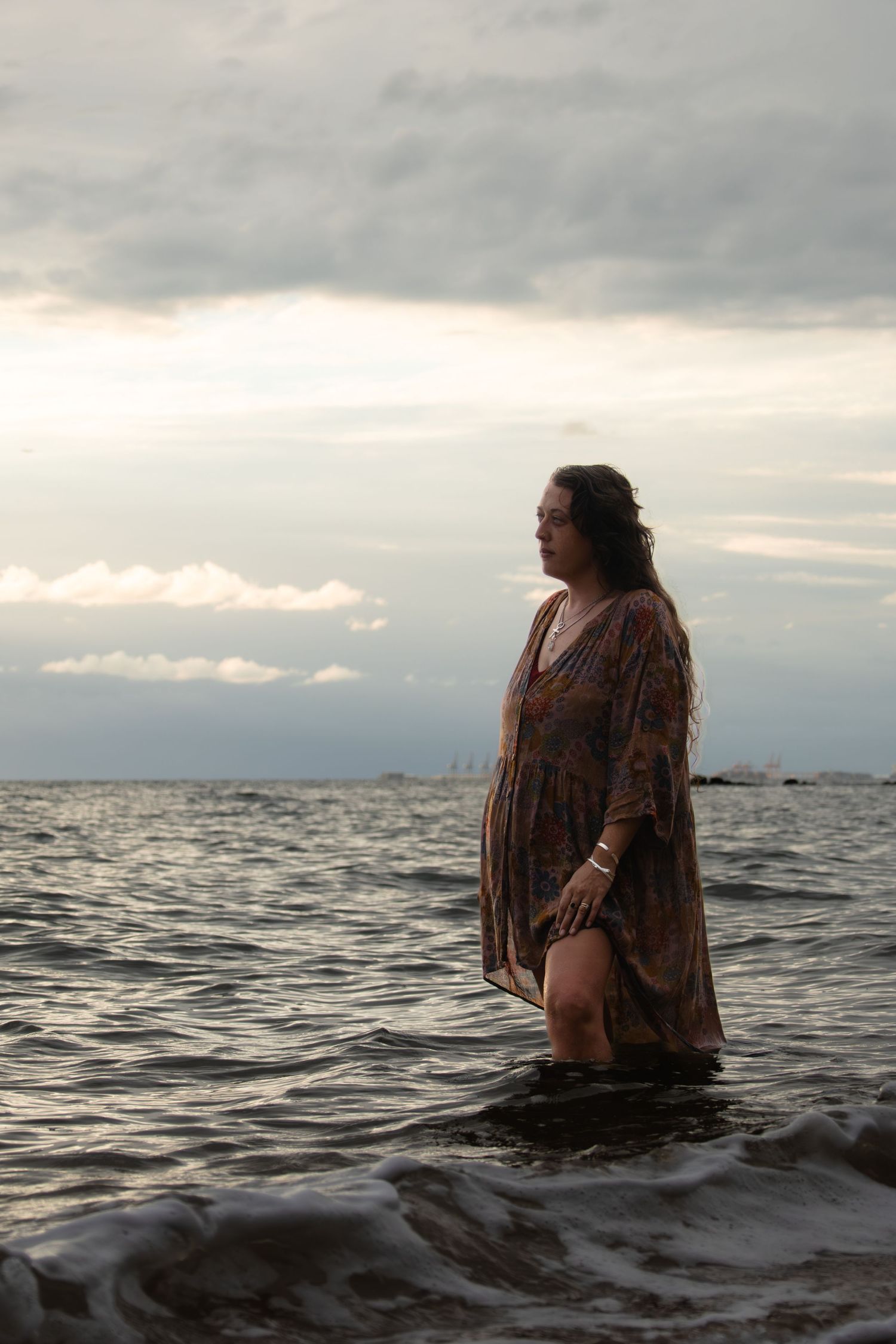 woman at sunrise standing in the water at the beach