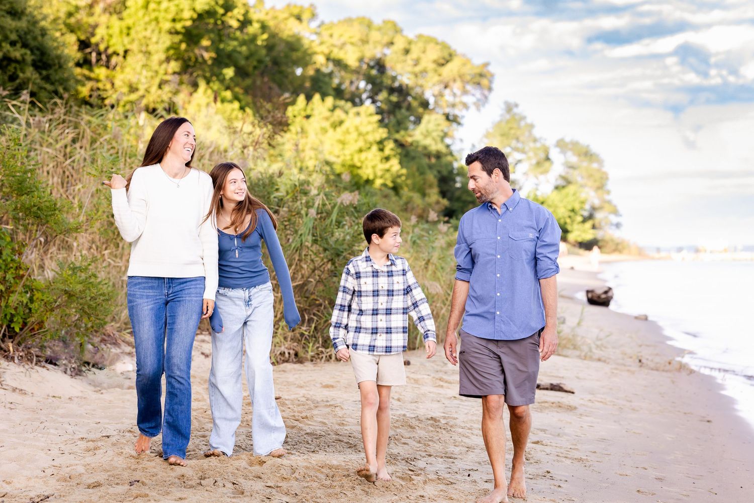 Family members walking together along a scenic beach path at sunset.