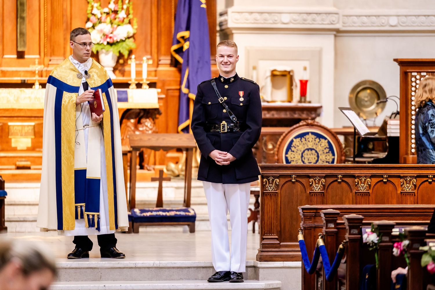 Church altar decorated with flowers and flags for a military wedding ceremony.