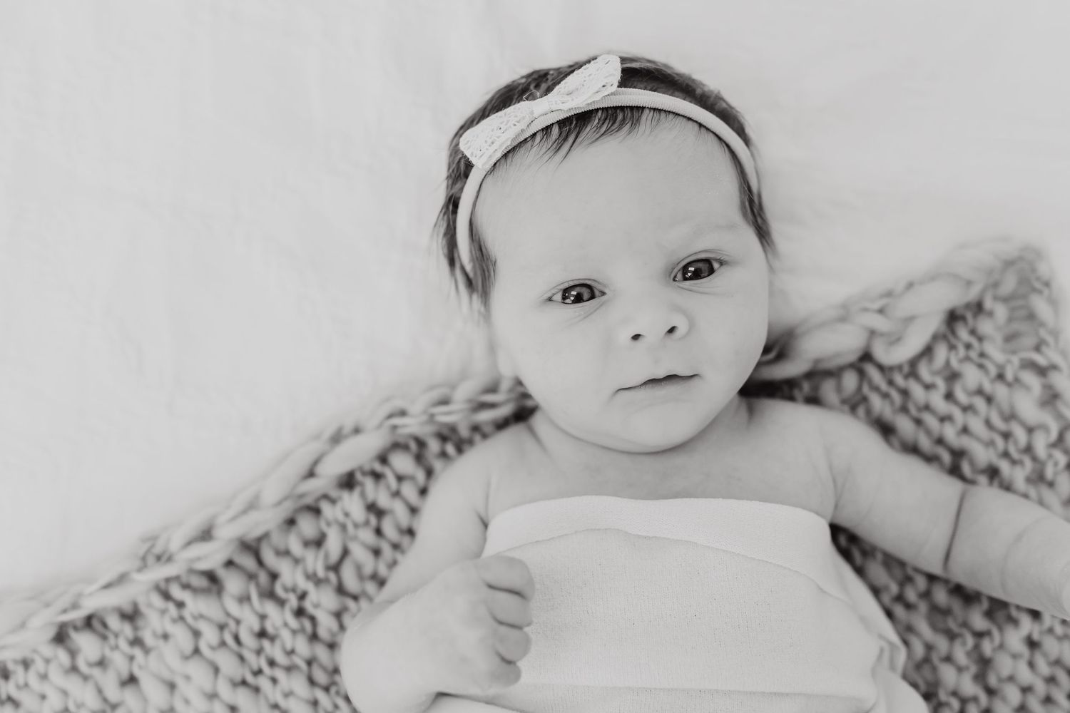 Collection of black and white baby portraits showing sweet sleeping expressions and delicate headbands.