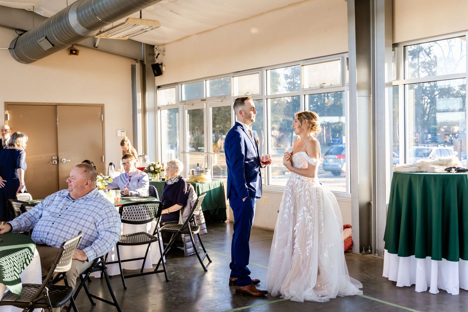 A wedding reception scene shows a couple standing together in a casual venue with guests seated nearby.