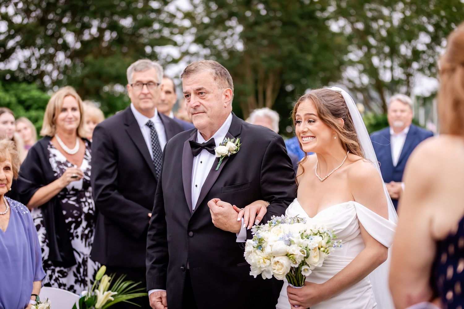 Wedding guests celebrate with joyful expressions during an outdoor reception.