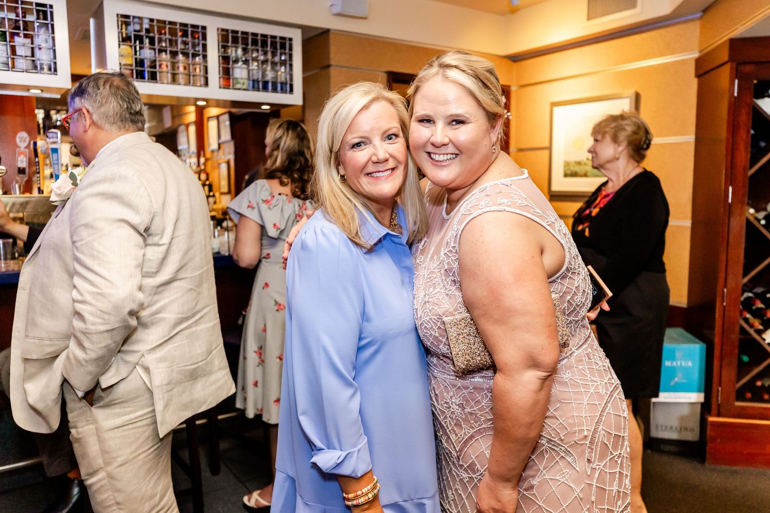 Party guests pose together for photo during indoor celebration event.