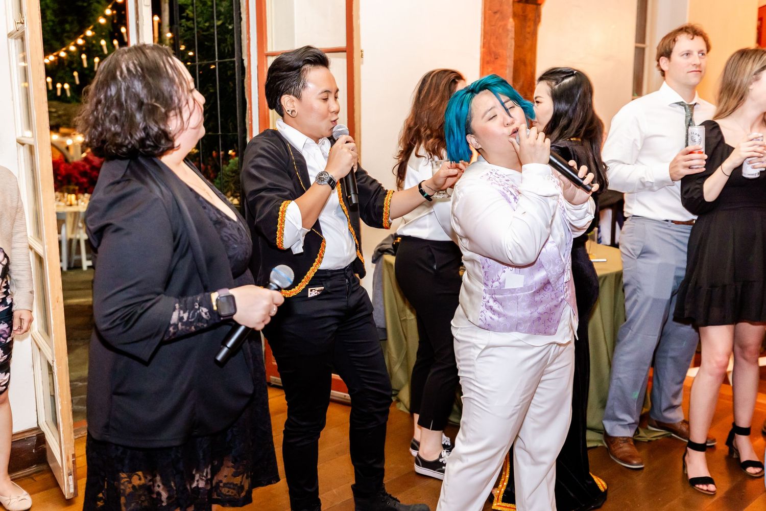 Party guests singing and dancing enthusiastically at an indoor celebration.