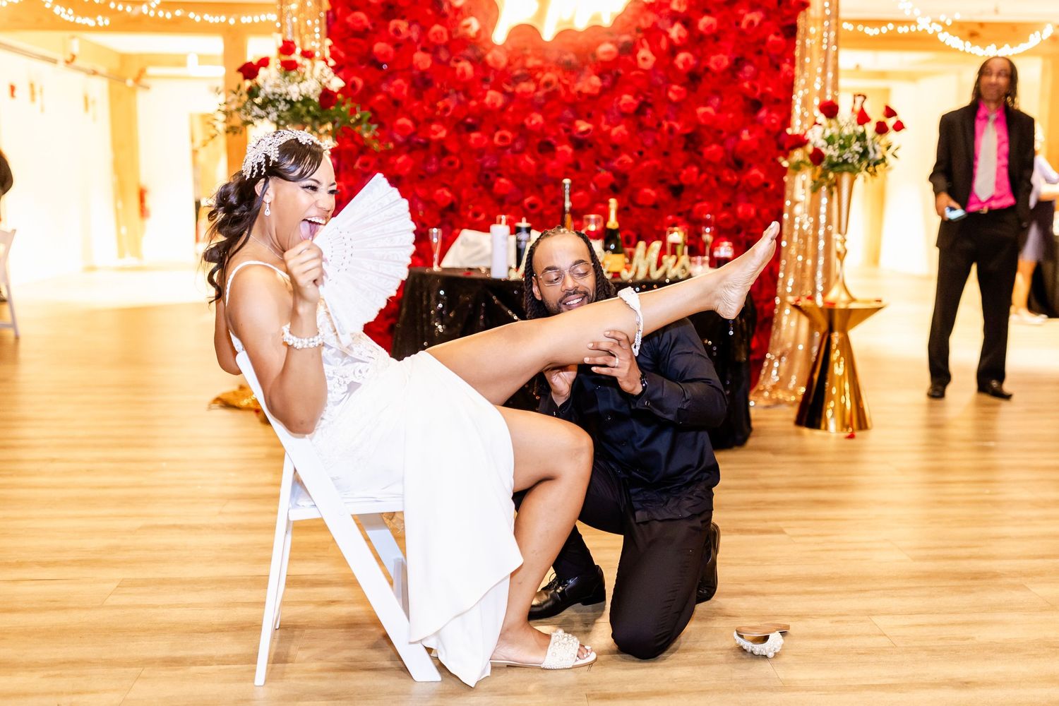 Wedding reception entertainment in front of a dramatic red balloon wall backdrop.
