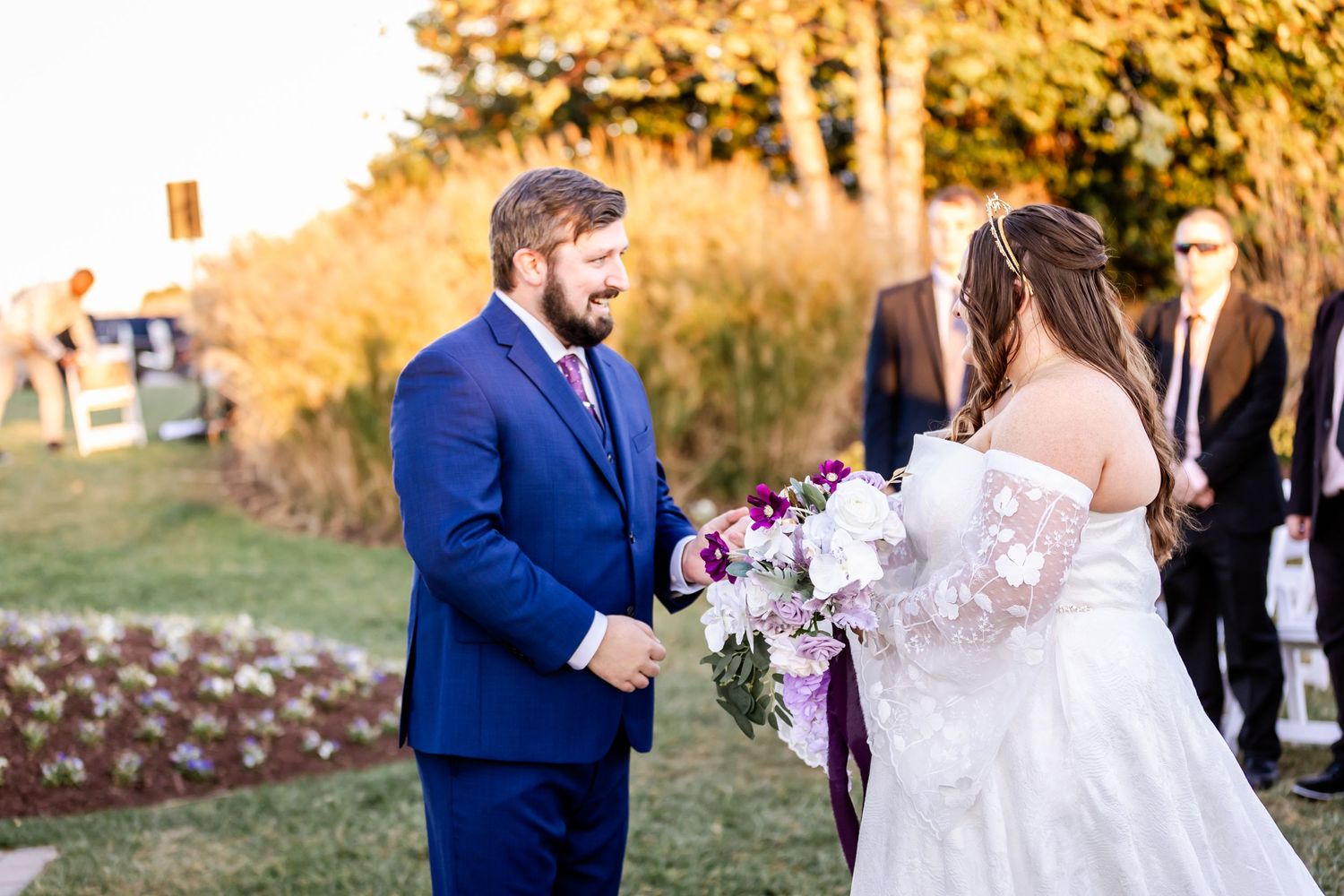Bride and groom share intimate moment during outdoor sunset wedding ceremony.