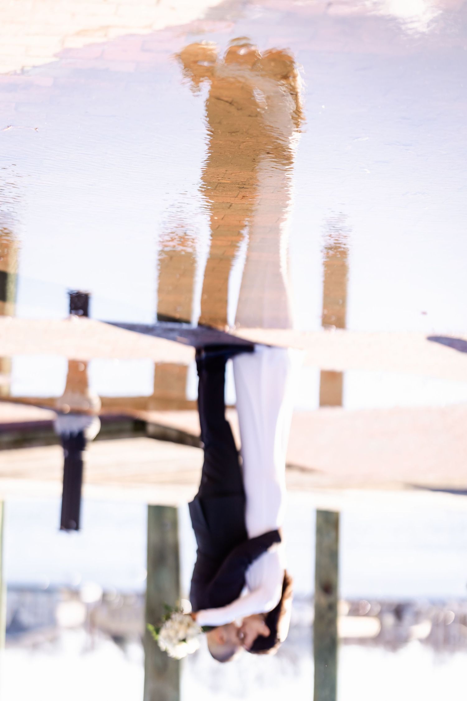 A reflection in water shows a couple's silhouette against a light background.