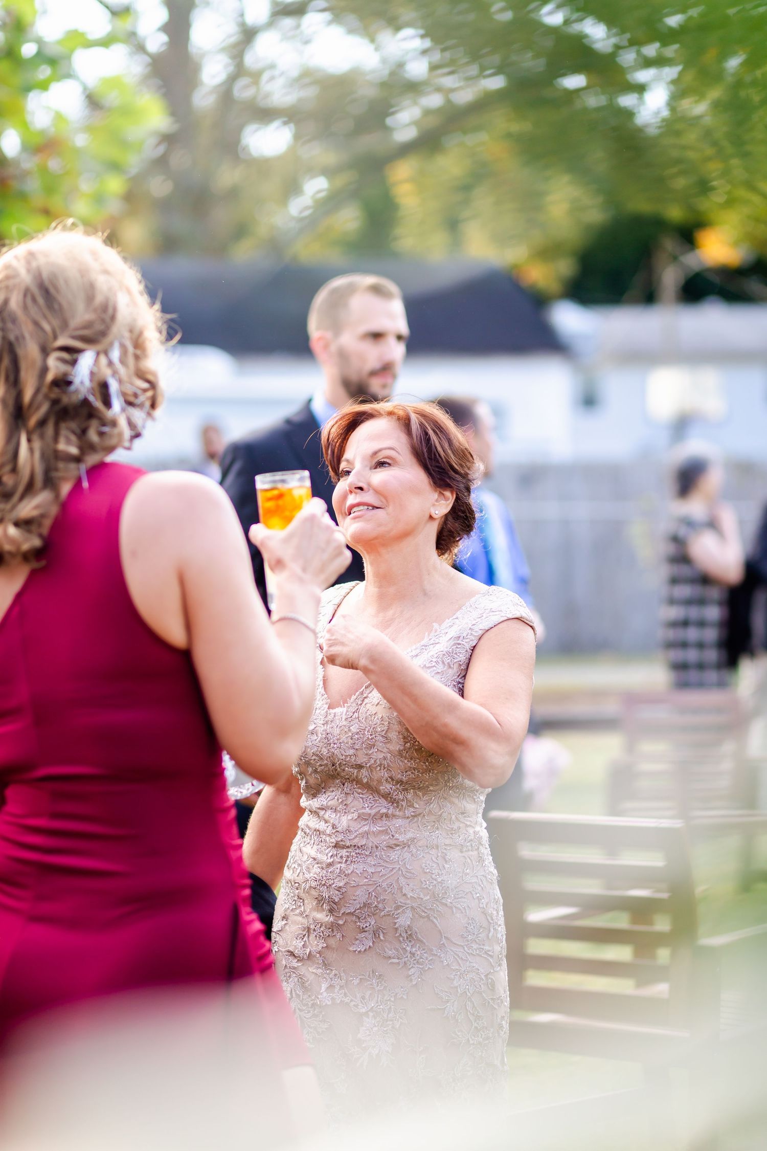Wedding guests enjoying conversation and drinks during an outdoor cocktail hour.