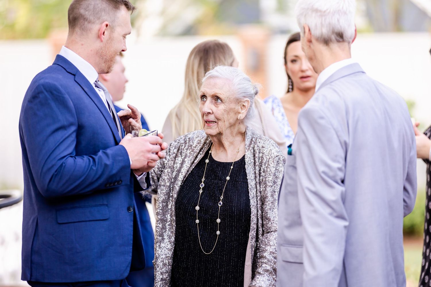 Wedding guests mingling and socializing during an outdoor cocktail reception.