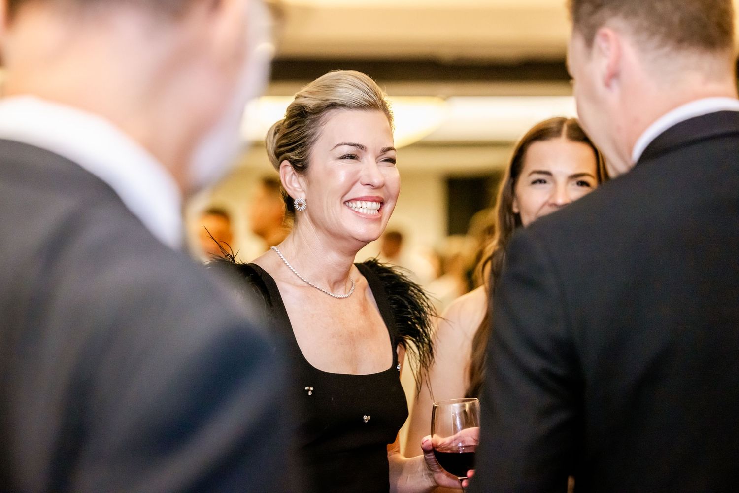 Wedding guests mingling and socializing at an indoor reception.