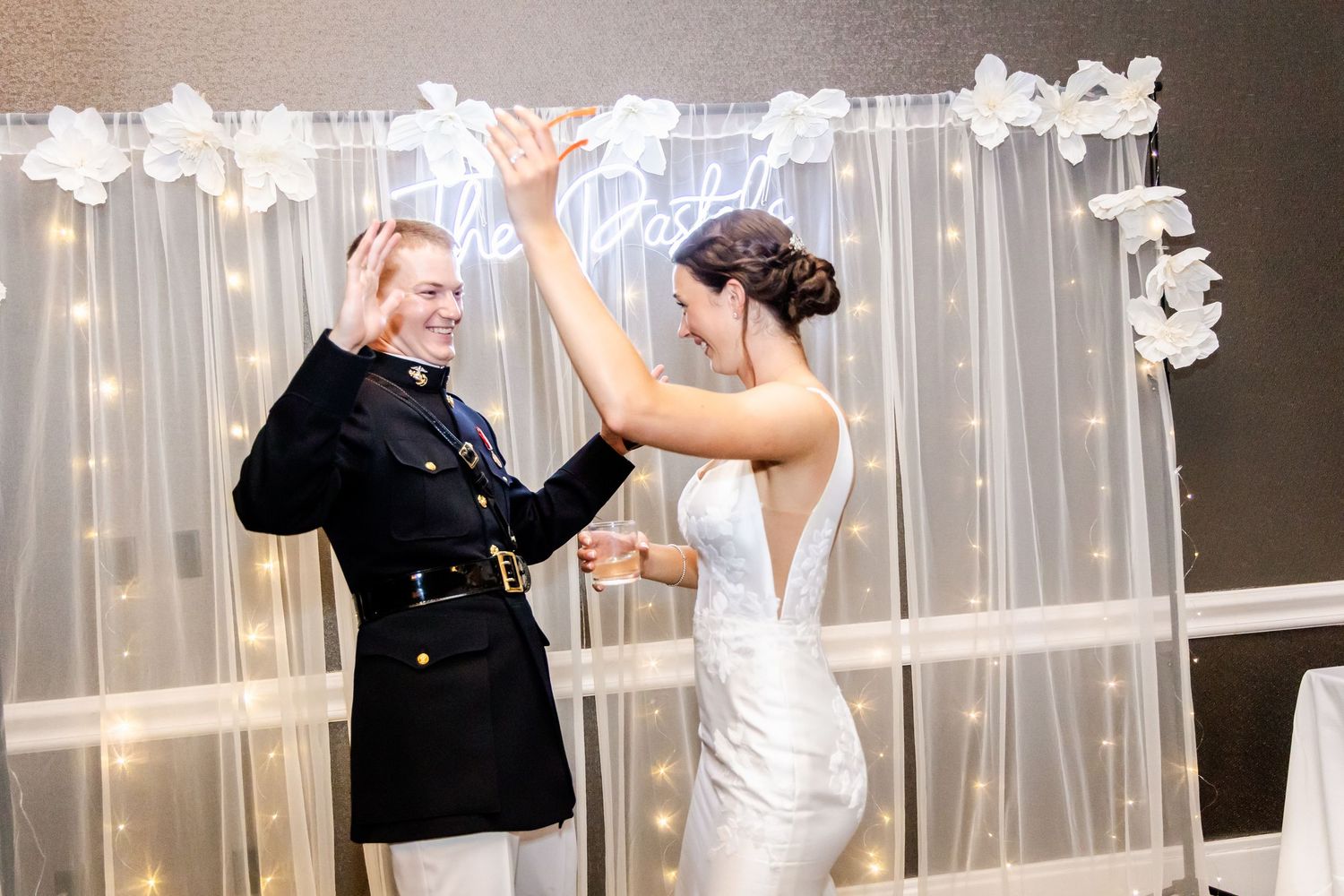 Wedding reception venue decorated with white curtains and string lights creating a romantic atmosphere.