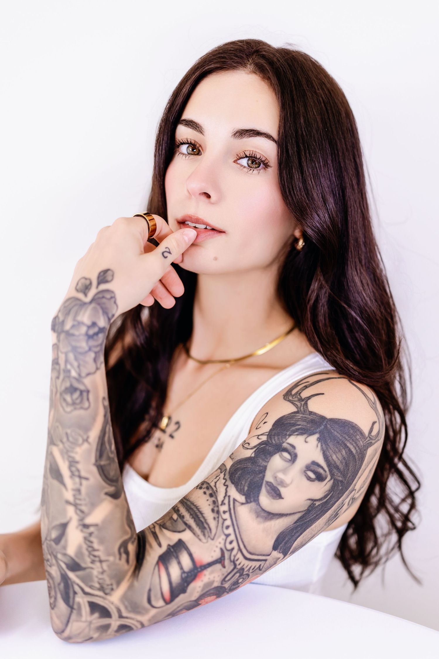 A series of artistic portrait shots showing detailed arm tattoos against a white background.