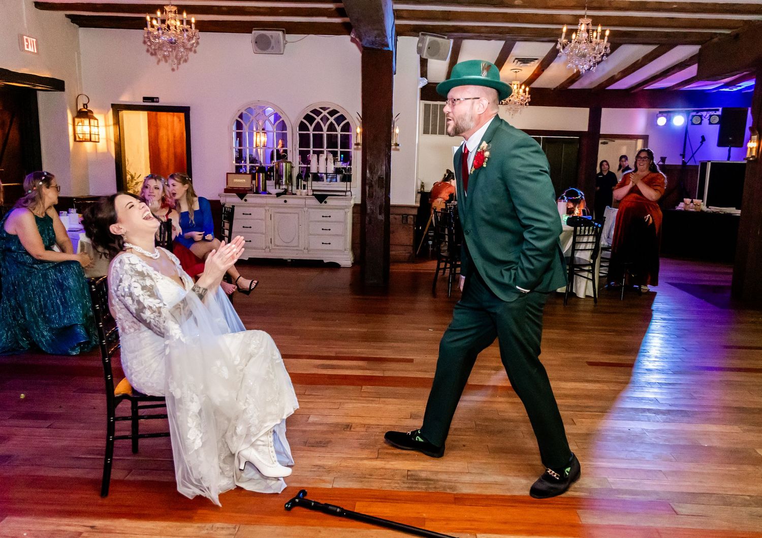 Dance floor scene at a wedding reception with wood floors and ambient lighting.
