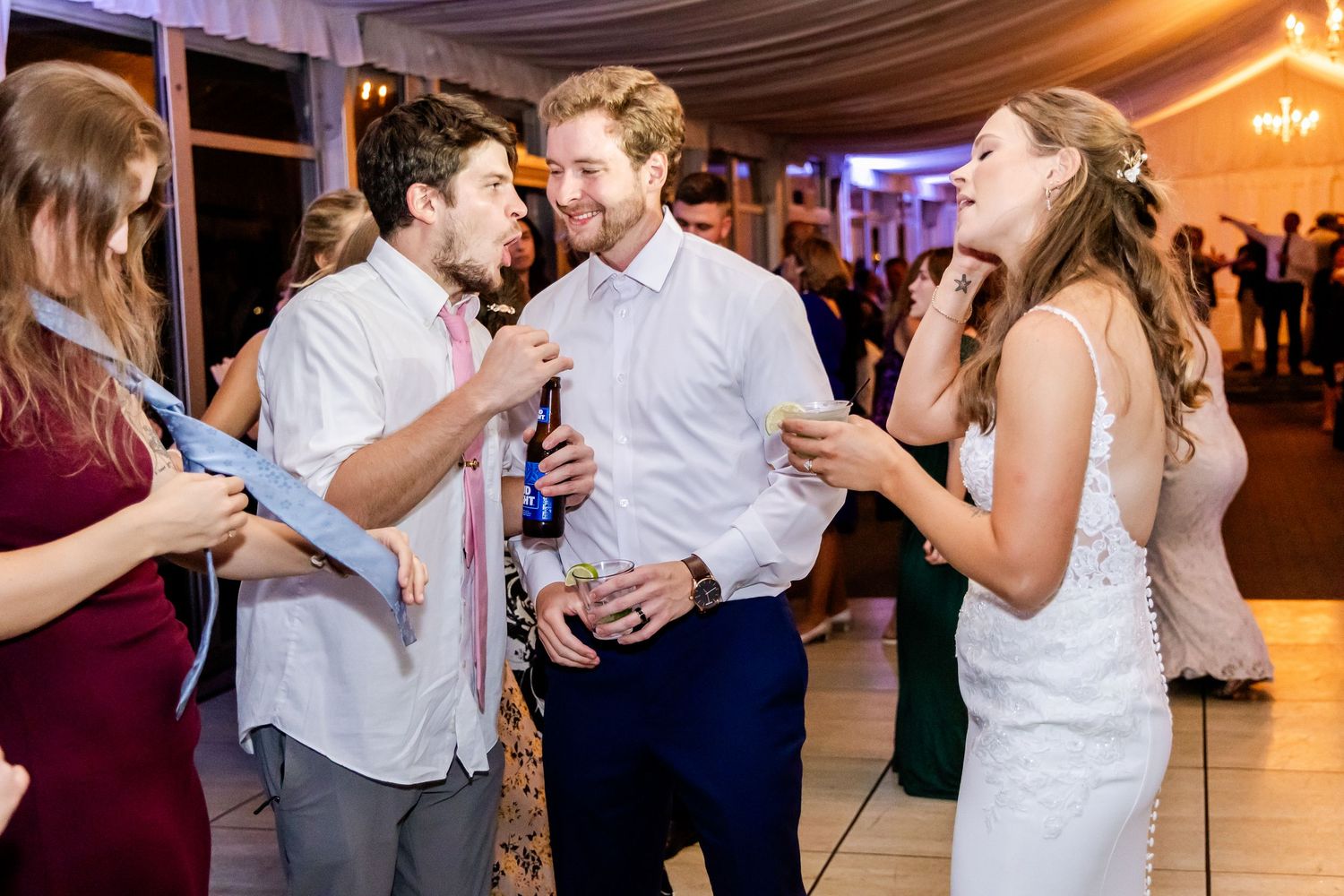 Lively dance floor filled with wedding guests enjoying themselves at an indoor reception.