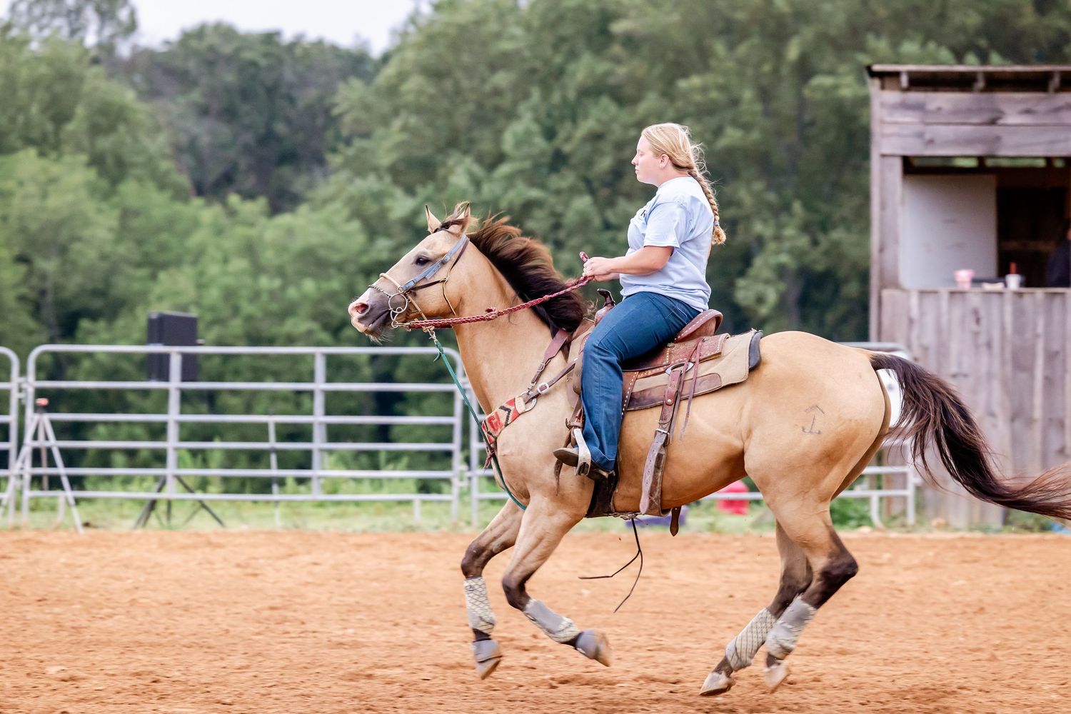 Action sequence of barrel racing competition with horse and rider racing across a dirt arena.