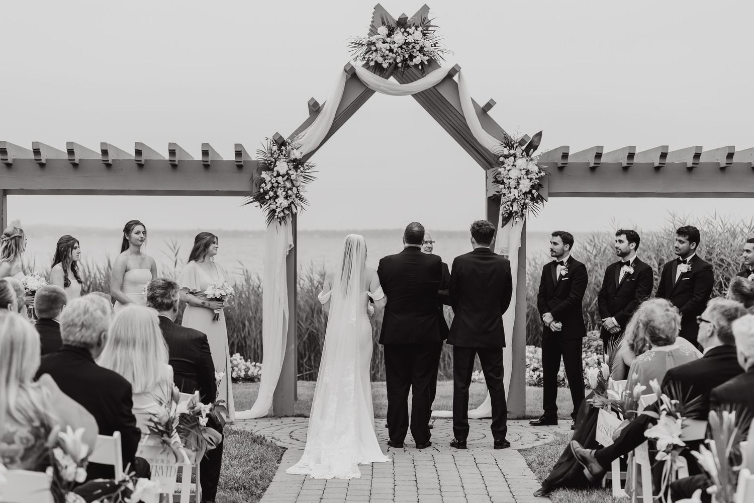 Black and white collage of wedding party photos showing outdoor celebration moments with guests and decorations.