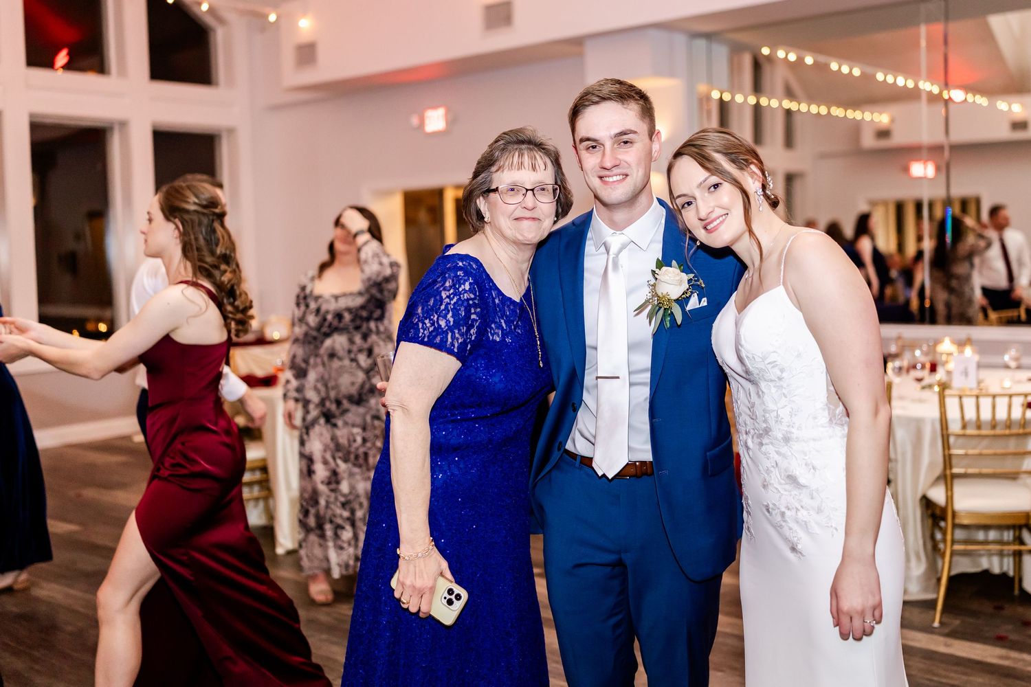 Wedding guests enjoying themselves on the dance floor in formal attire at an evening reception.