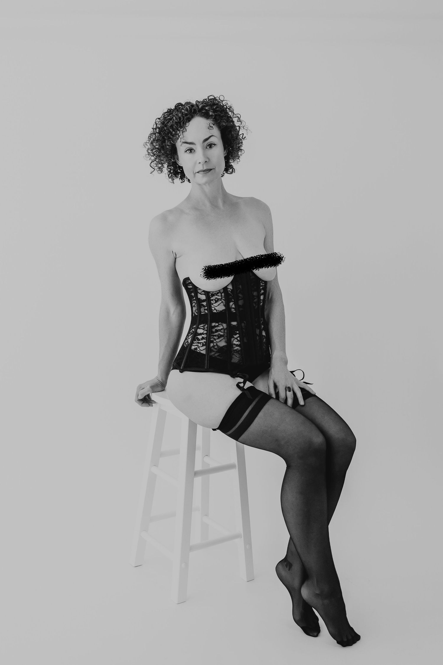 A collection of black and white portraits showing someone posing gracefully on a white stool in dark attire.
