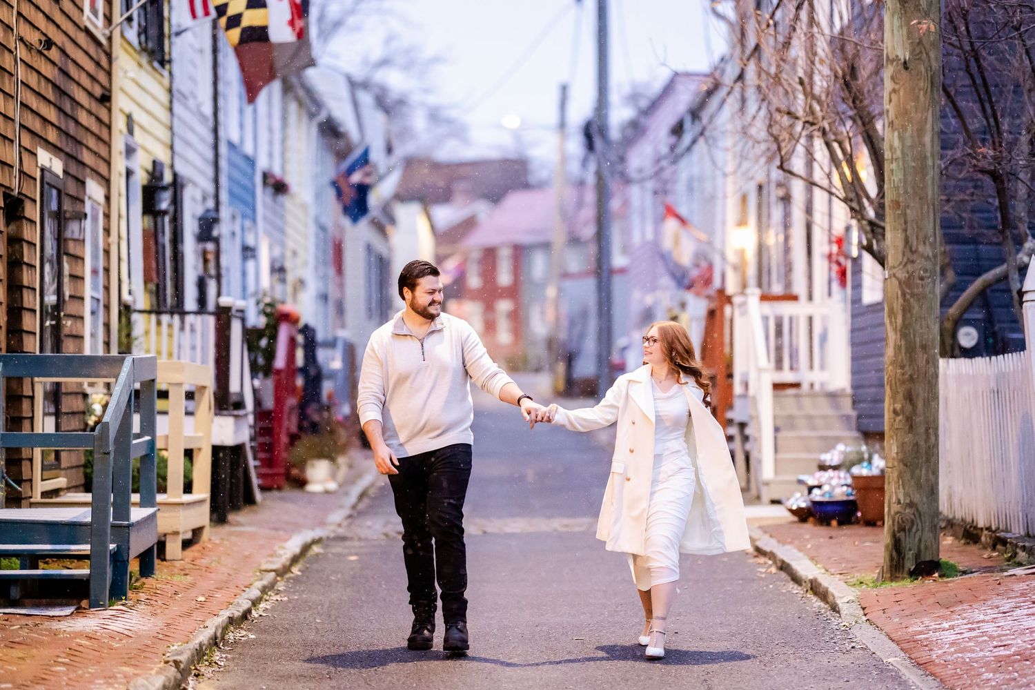 A series of romantic engagement photos showing a couple walking and dancing on a cobblestone street at sunset.