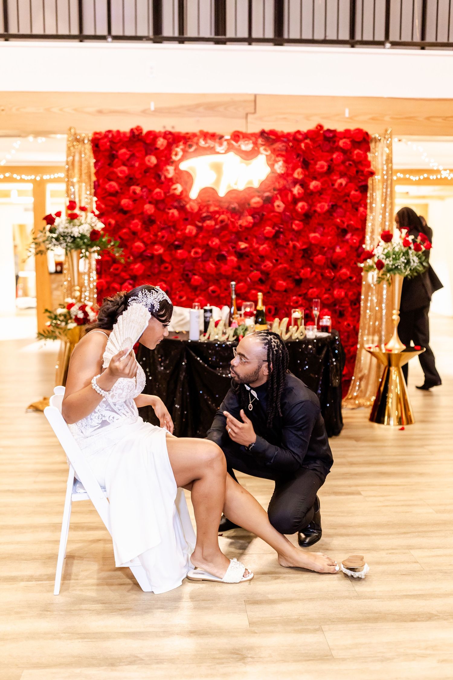 A wedding scene with a dramatic red balloon wall backdrop and couple on dance floor.