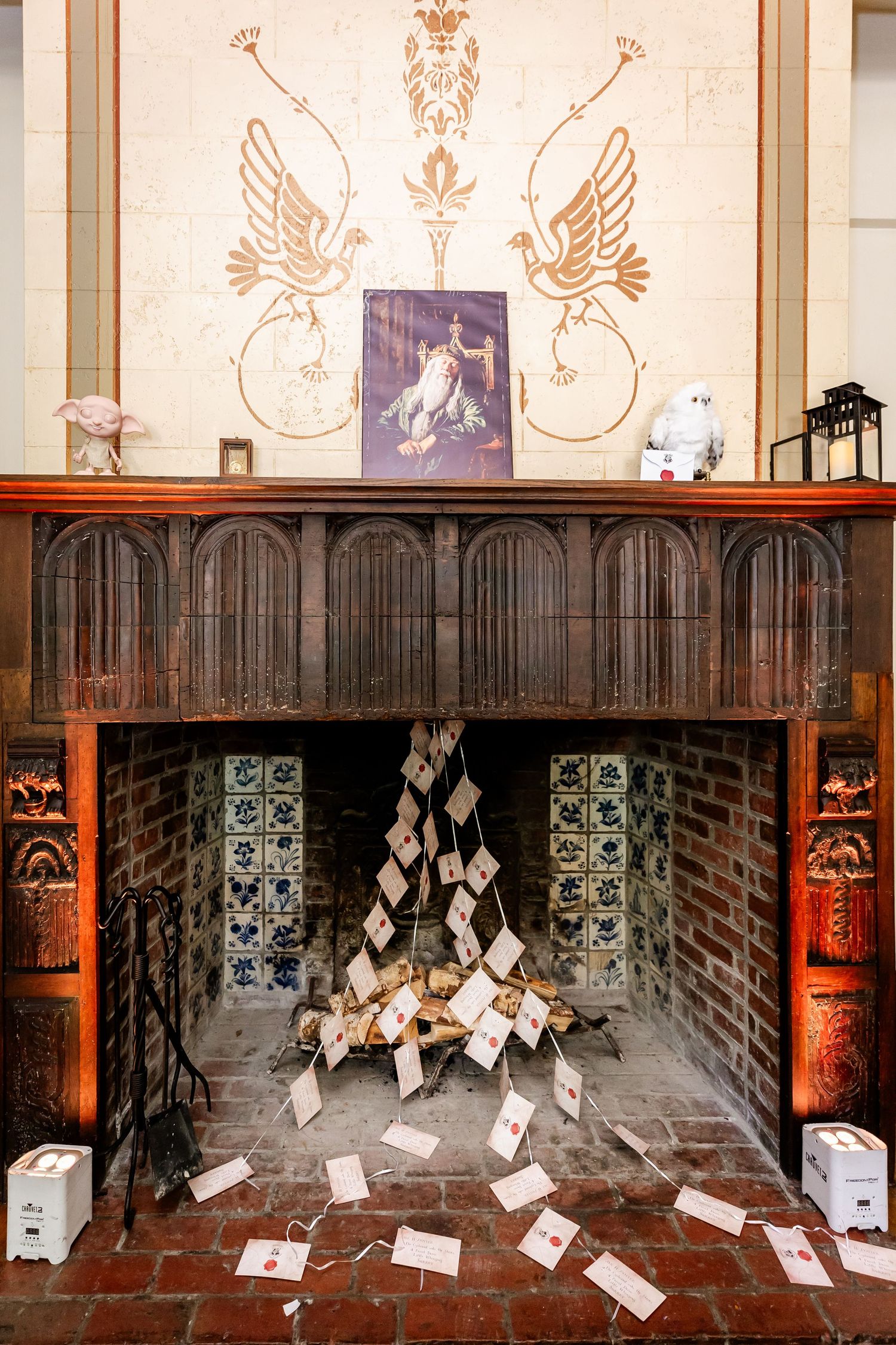 Vintage fireplace decorated with flying bird motifs and scattered letters in an artistic display.