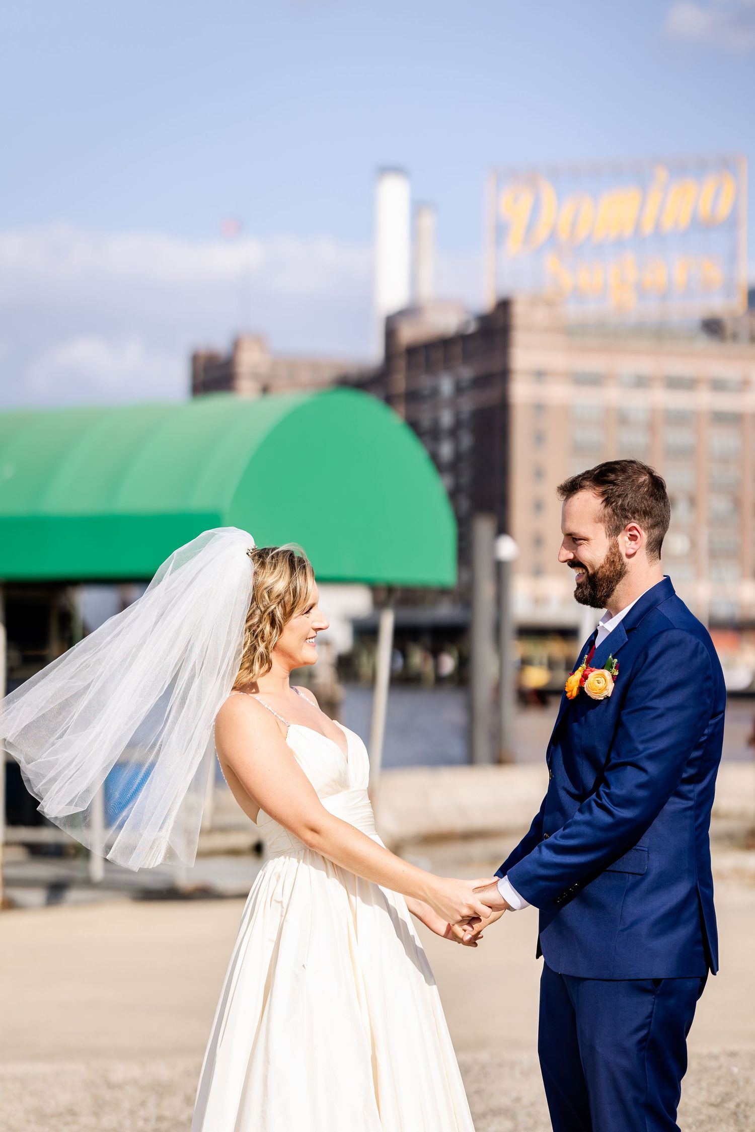 A sequence of photos shows a couple in wedding attire walking and laughing together outdoors near an urban building.