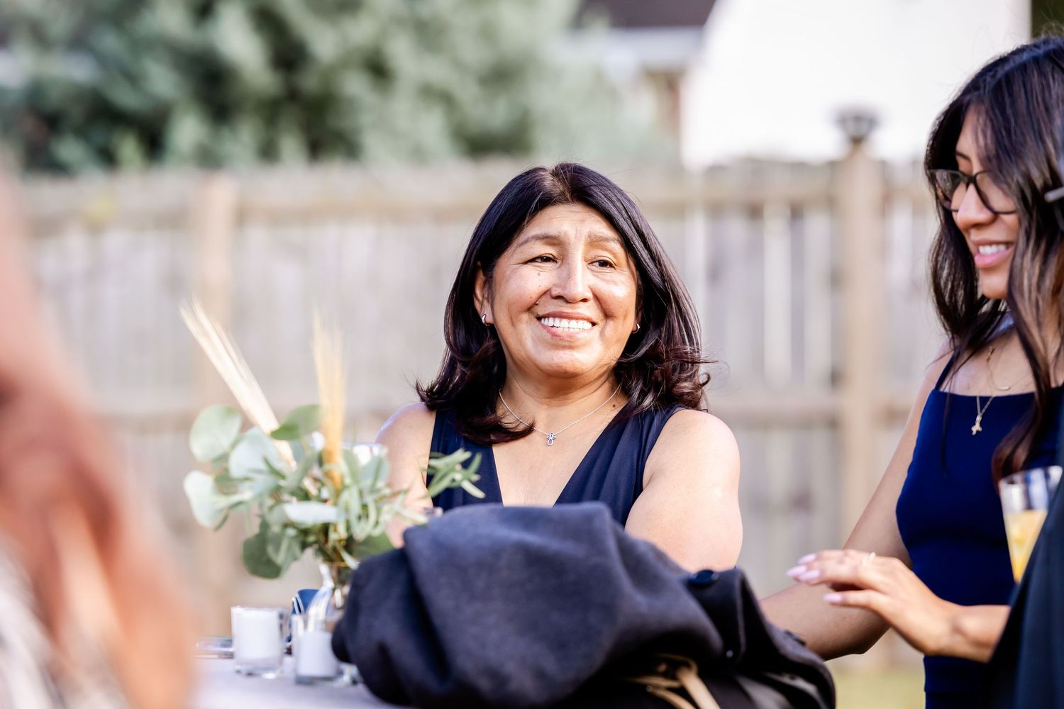 Wedding party members share joyful laughter during outdoor celebration.