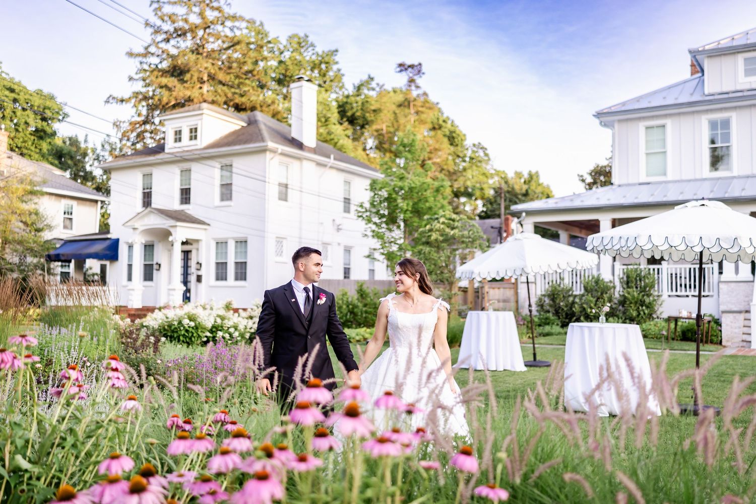 Wedding venue surrounded by blooming pink flowers and lush greenery.