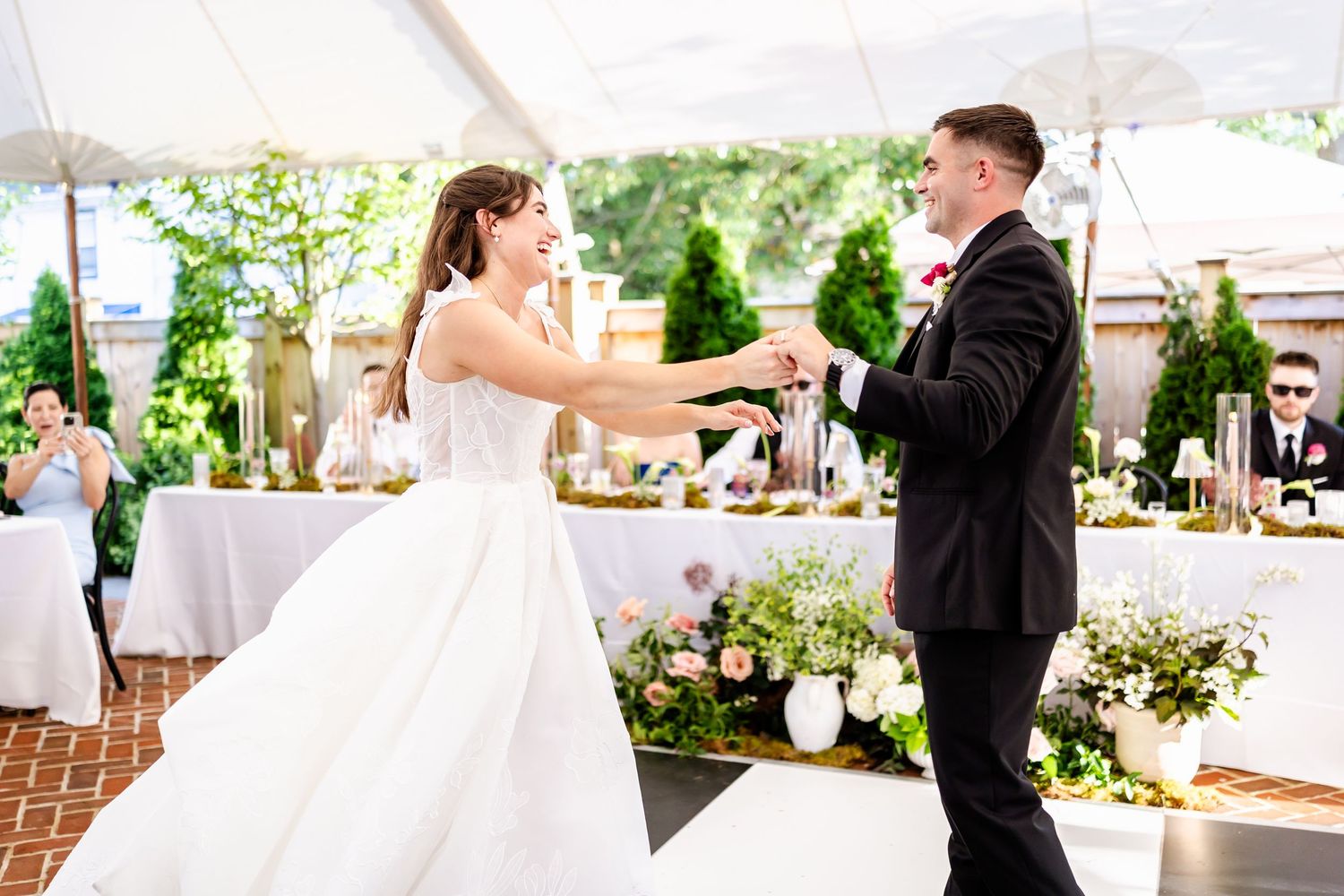 Wedding couple sharing a romantic dance moment under an outdoor tent.