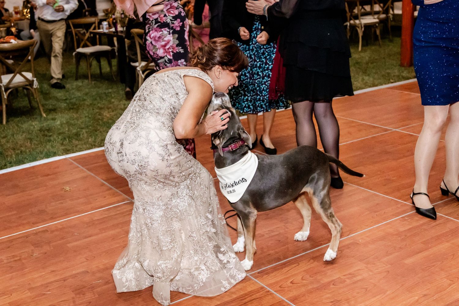 Wedding guests dancing and celebrating on reception dance floor.