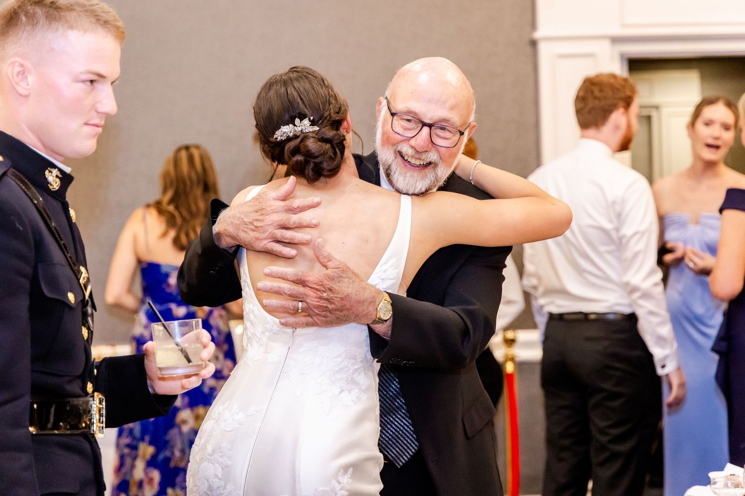 Wedding reception guests dancing and embracing on the dance floor.