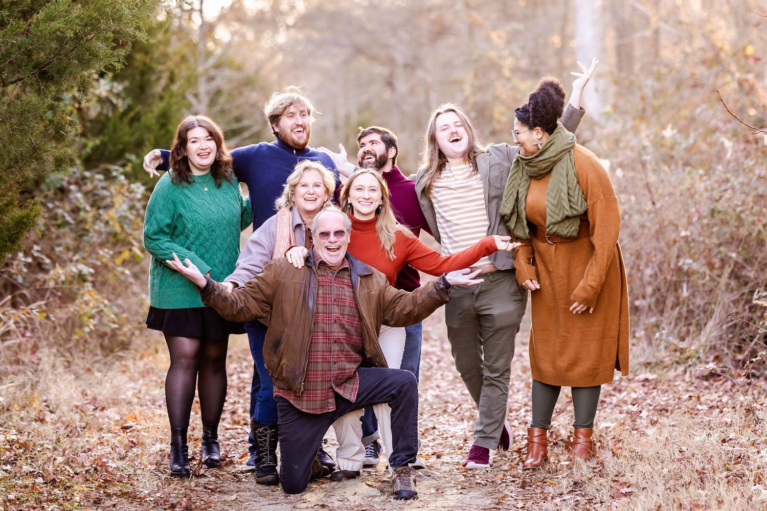 Group of people walking together through autumn field during outdoor photoshoot.