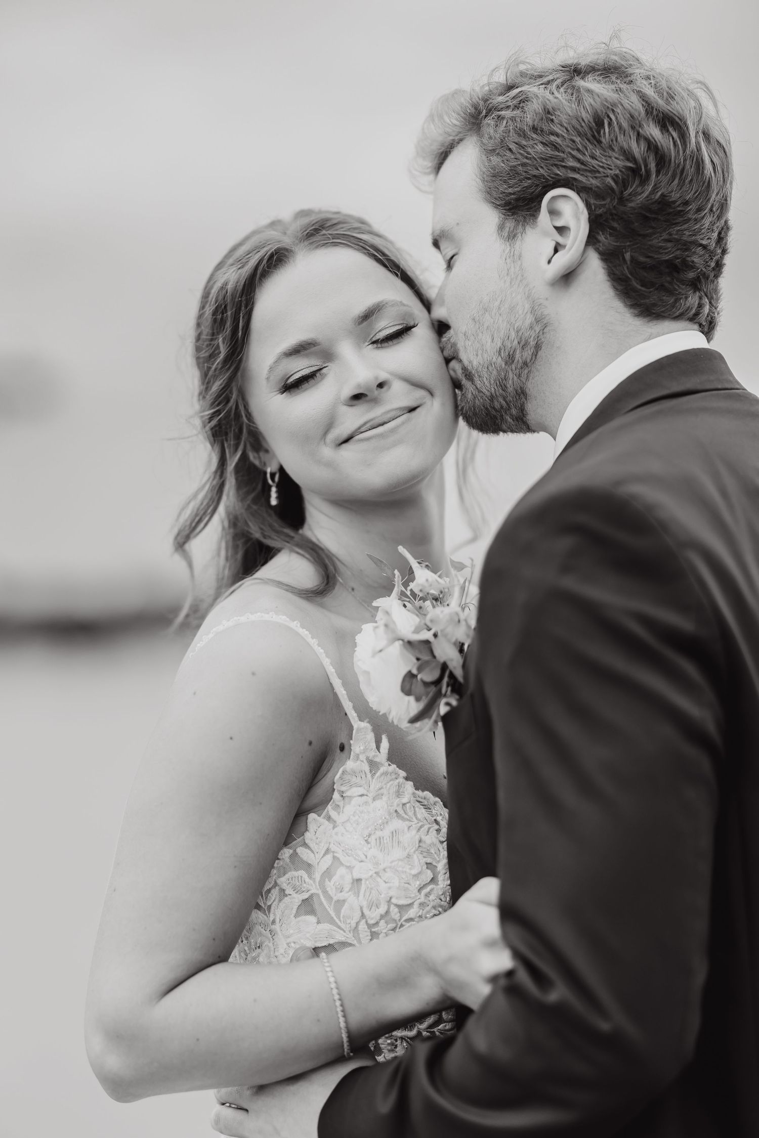 Black and white romantic wedding portraits showing tender moments between newlyweds in formal attire.