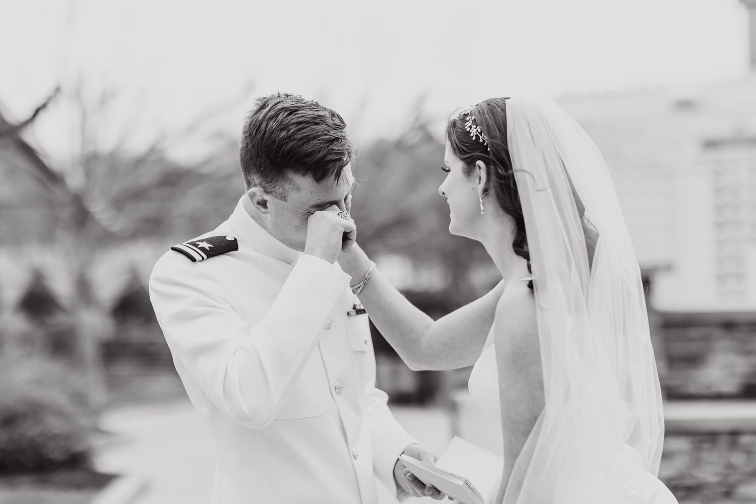 Black and white vintage style portrait of a bride and groom sharing an intimate moment during their wedding ceremony.
