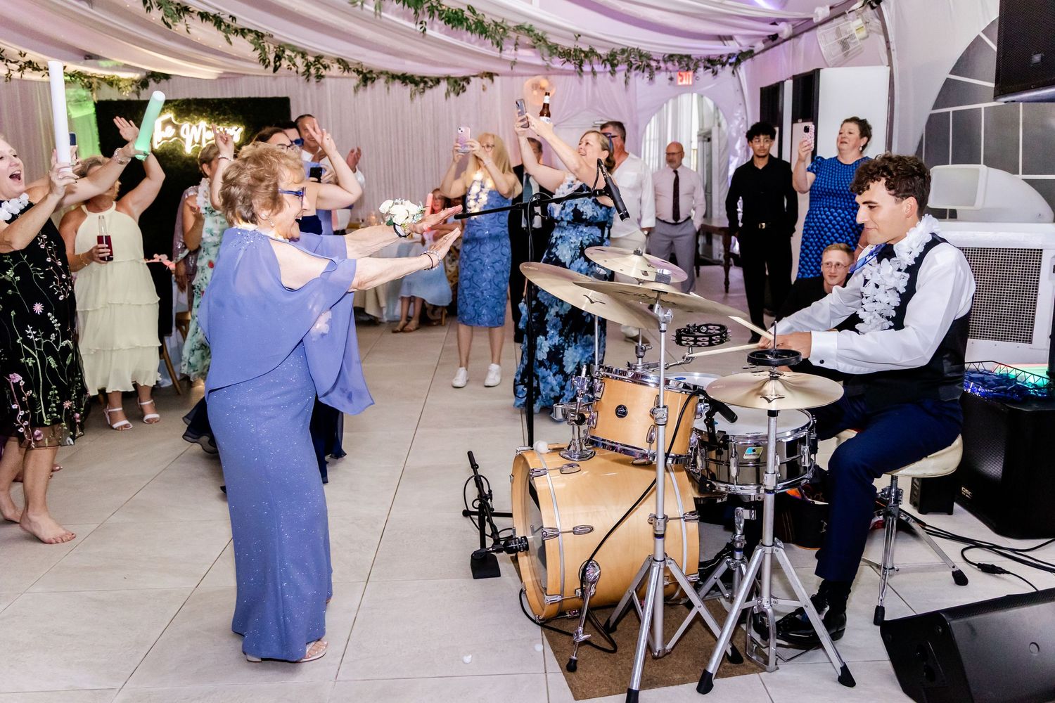 Wedding guests dance and celebrate on the dance floor during a lively reception party.