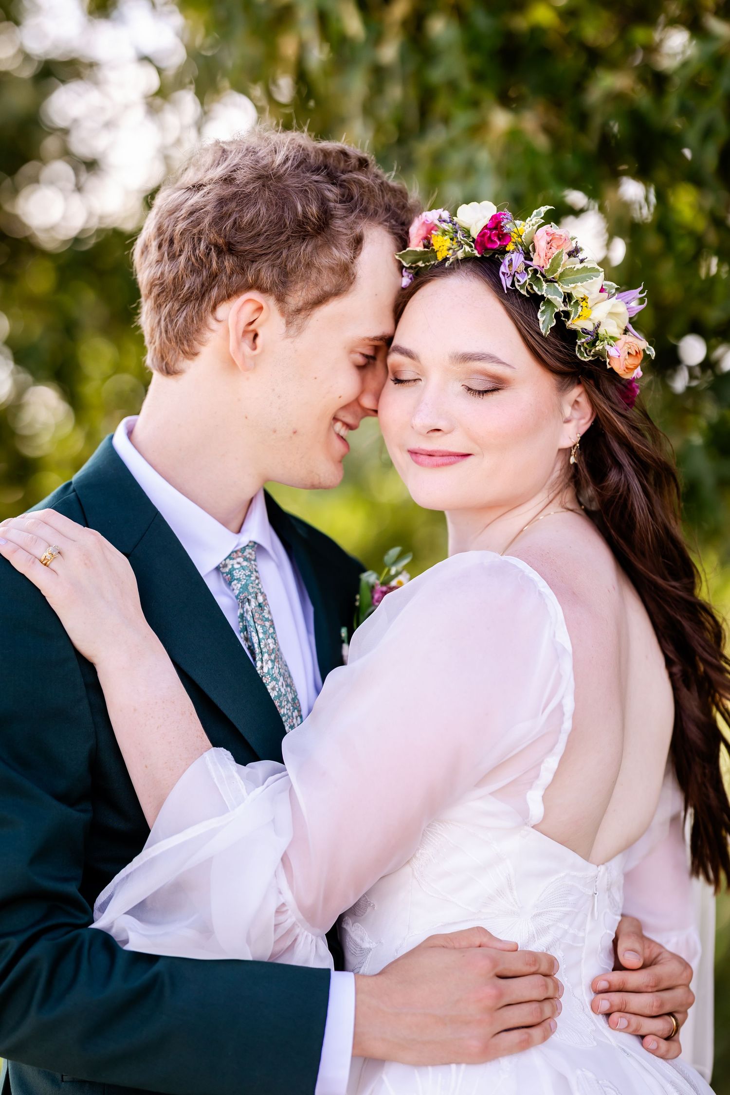 A romantic wedding couple shares intimate moments in an outdoor garden setting with natural lighting and floral details.