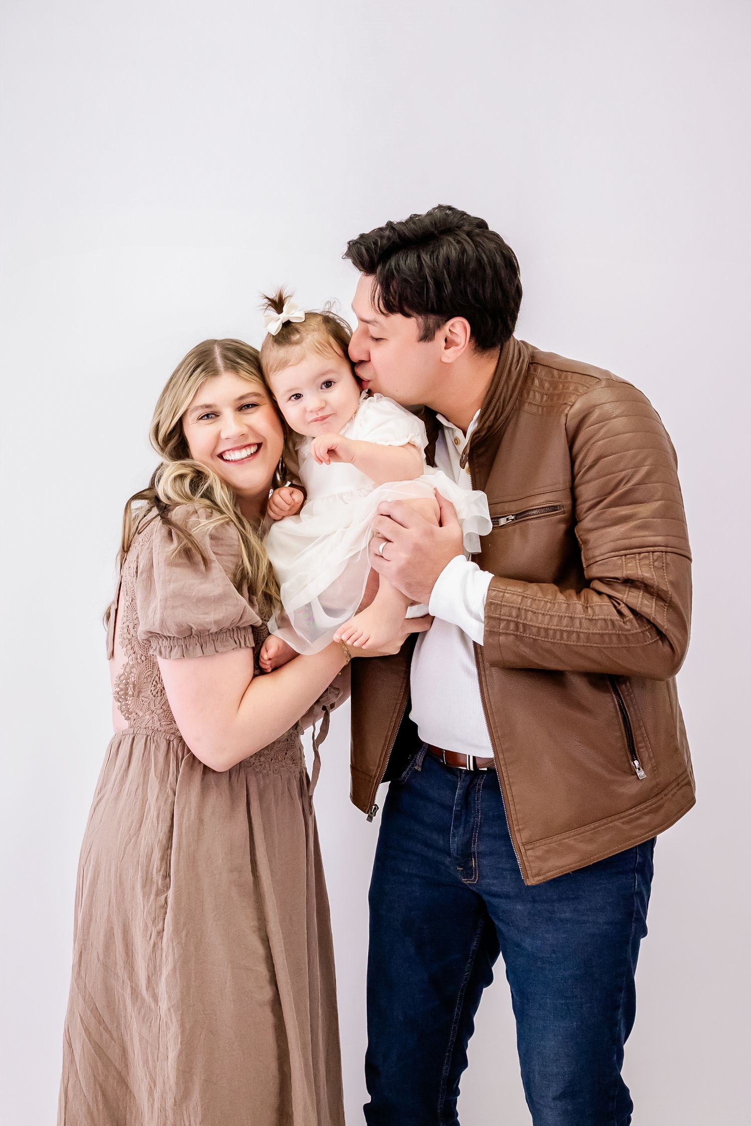 A family photo session showing joyful interactions against a white studio background.