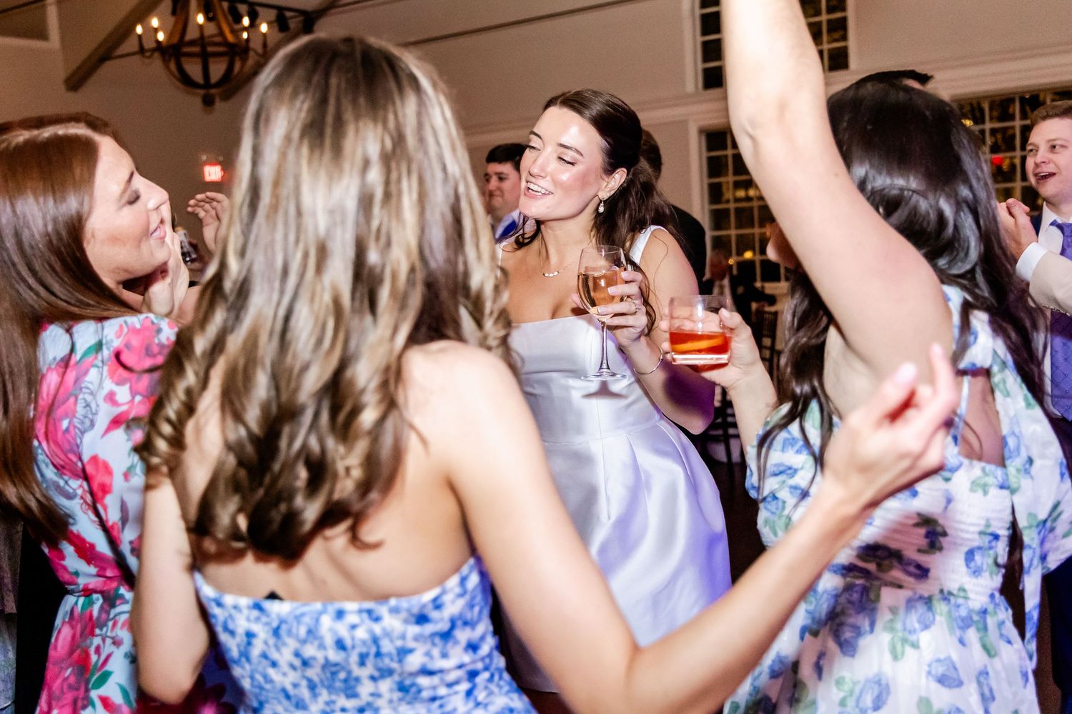 Wedding reception guests dancing and celebrating on the dance floor.