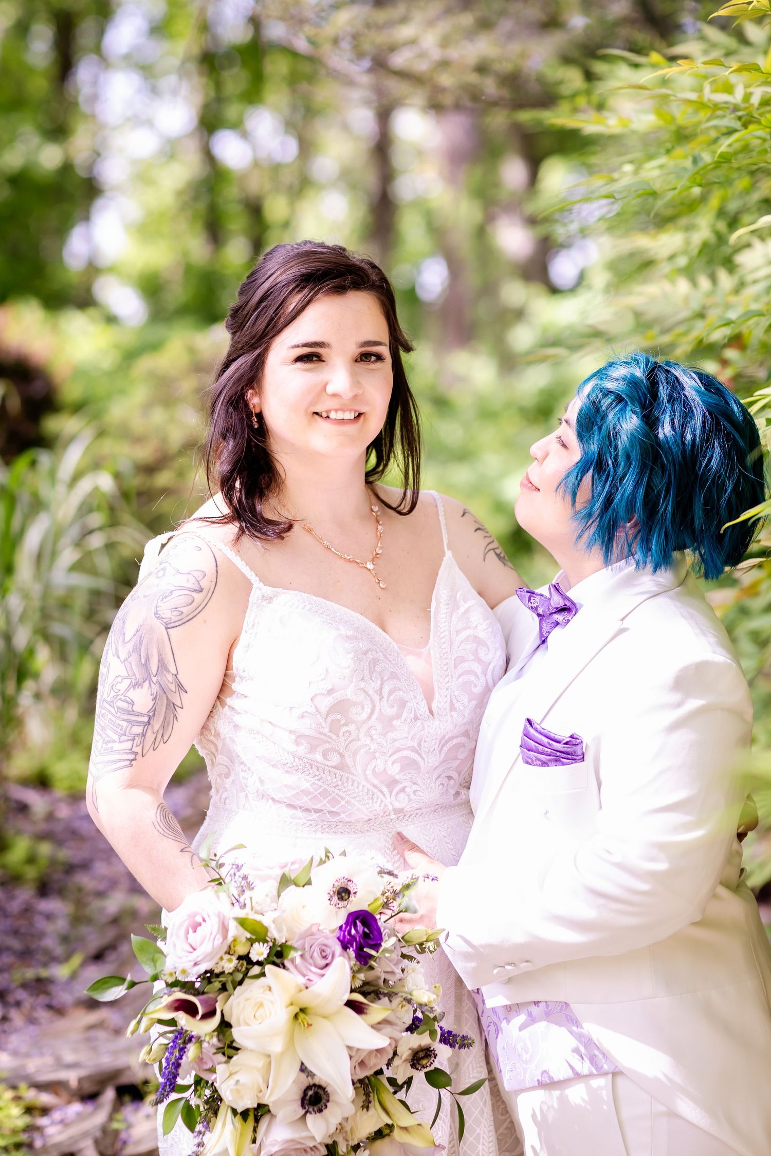 A tender moment between newlyweds in a garden setting with a beautiful floral bouquet.