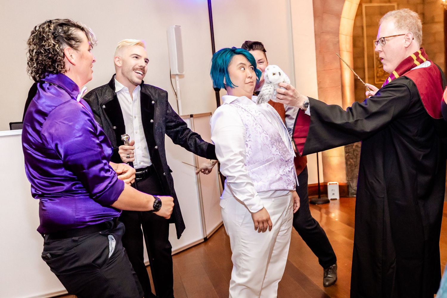 Celebrants in formal attire dancing and interacting during indoor event.
